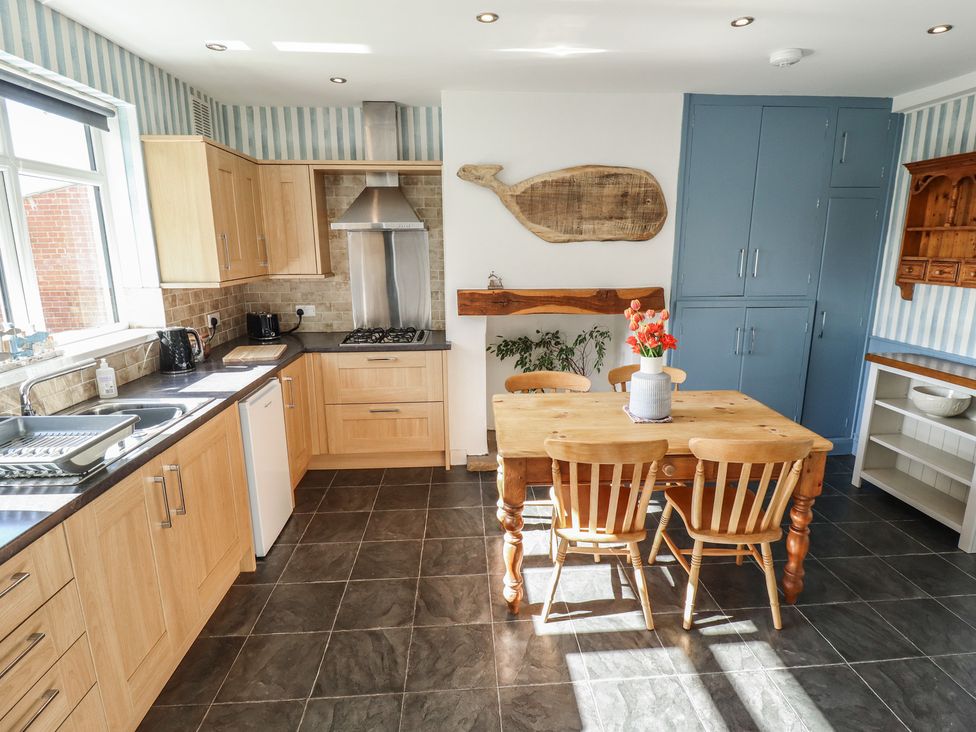 A kitchen with a table and chairs at Sorrento in Mablethorpe