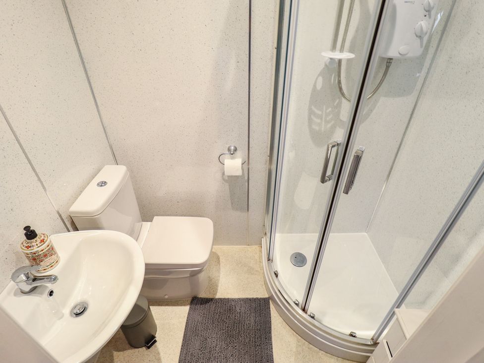 A bathroom with a shower, sink, and toilet at Sorrento in Mablethorpe