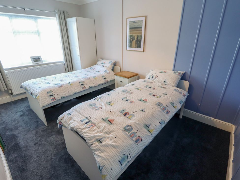 A bedroom with two beds and a wardrobe at Sorrento in Mablethorpe