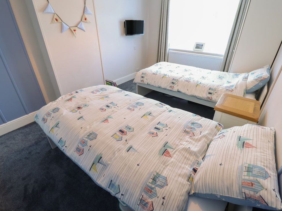 A bedroom with two beds and a television at Sorrento in Mablethorpe