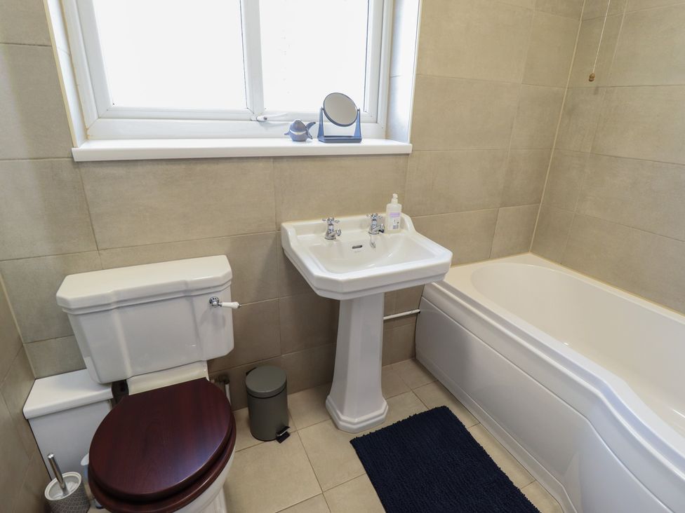 A bathroom with a bathtub, sink, and toilet at Sorrento in Mablethorpe