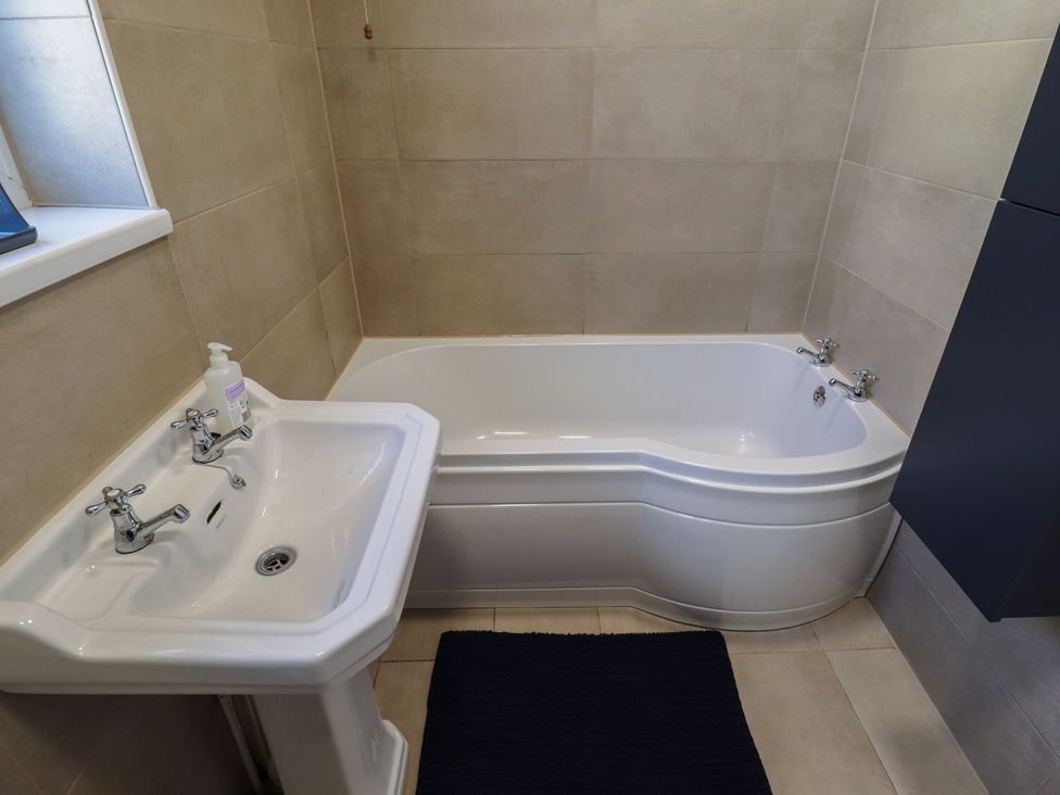 A bathtub and sink in a bathroom at Sorrento in Mablethorpe