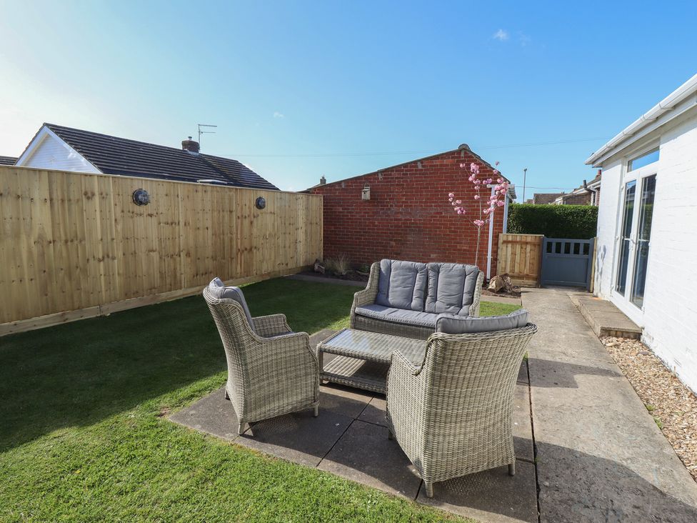 A garden with wicker furniture and fence at Sorrento in Mablethorpe