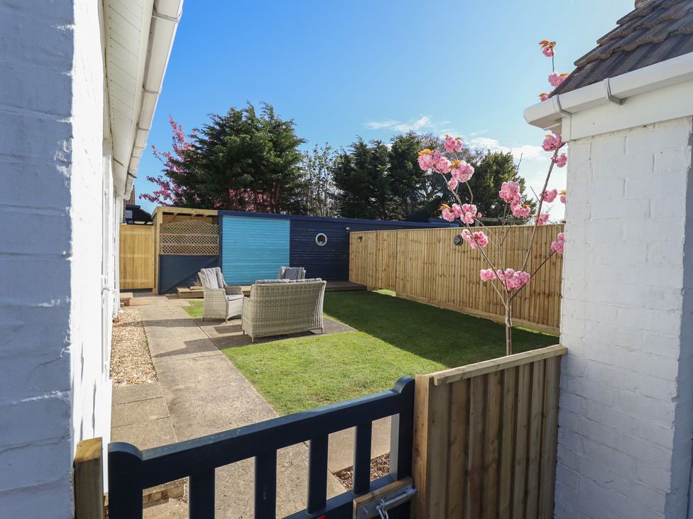 A garden with chairs and a storage shed at Sorrento in Mablethorpe