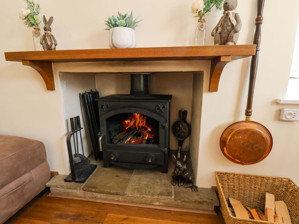 A fireplace with a log burner and decorative figures at The Nook in Robin Hood’s Bay