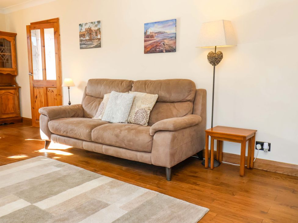 A living room with a sofa and lamp at The Nook in Robin Hood’s Bay
