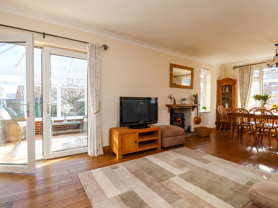 A living room with a television and dining area at The Nook in Robin Hood’s Bay