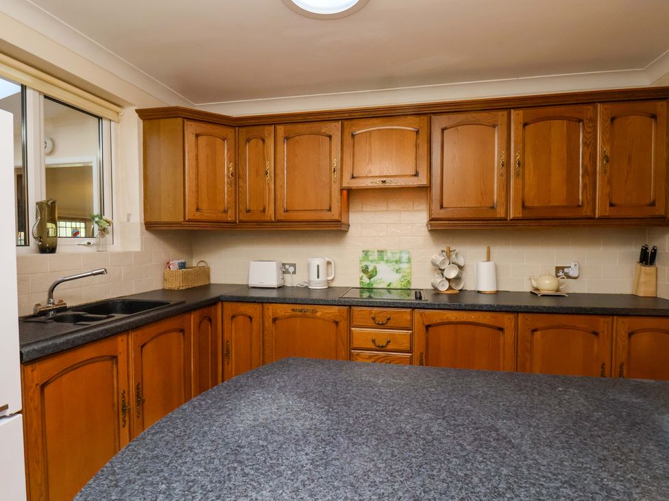 A kitchen with cabinets and appliances at The Nook in Robin Hood’s Bay