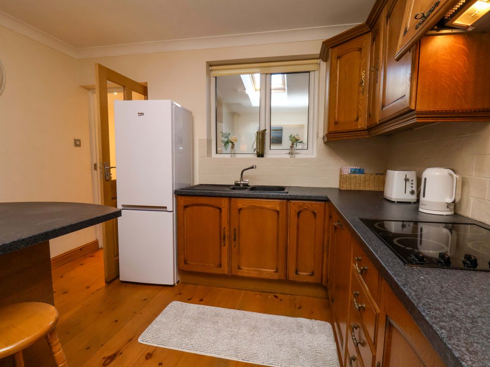A kitchen with a refrigerator, sink, and hob at The Nook in Robin Hood’s Bay