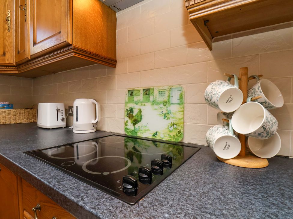 A kitchen with kettle, toaster, and cooking surface at The Nook in Robin Hood’s Bay