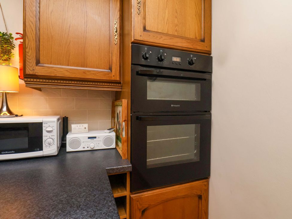 A kitchen with an oven, microwave, and radio at The Nook in Robin Hood’s Bay