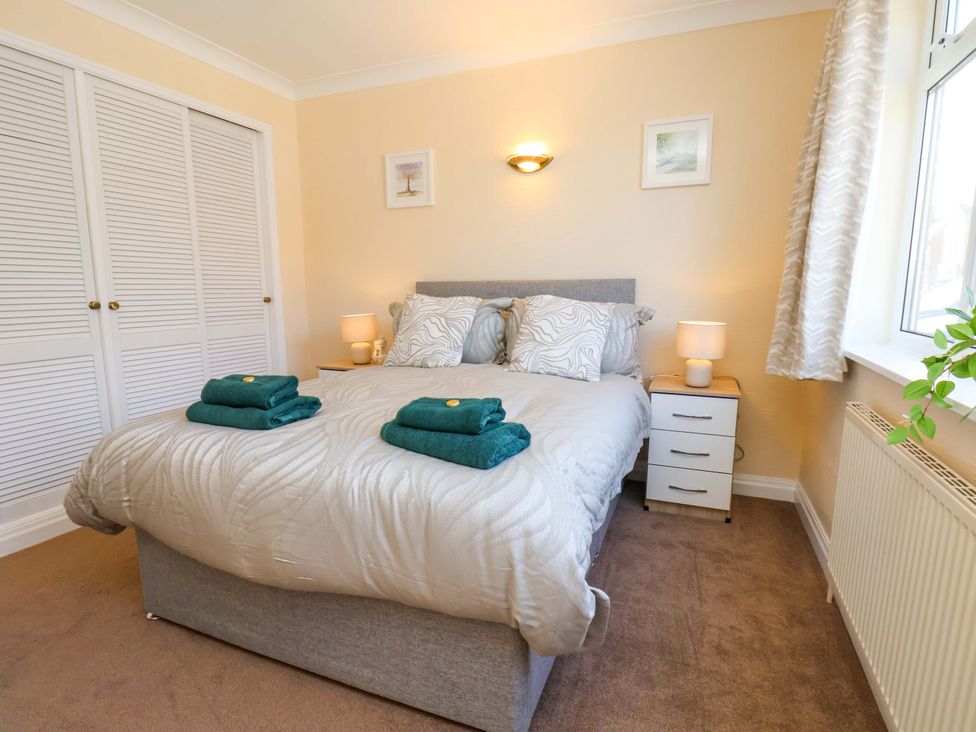 A bedroom with a bed and nightstand at The Nook in Robin Hood’s Bay