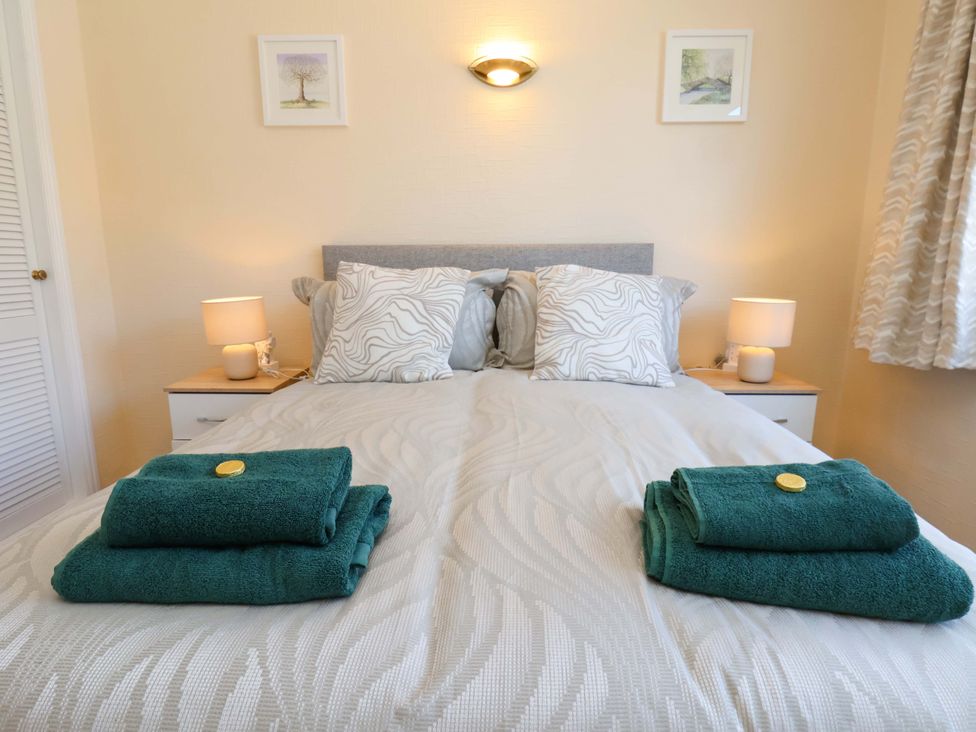 A bedroom with towels and pillows on a bed at The Nook in Robin Hood’s Bay
