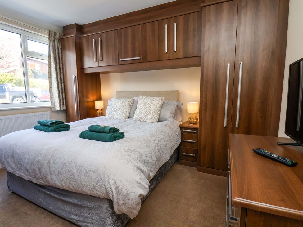 A bedroom with a bed, wardrobe, and television at The Nook in Robin Hood’s Bay