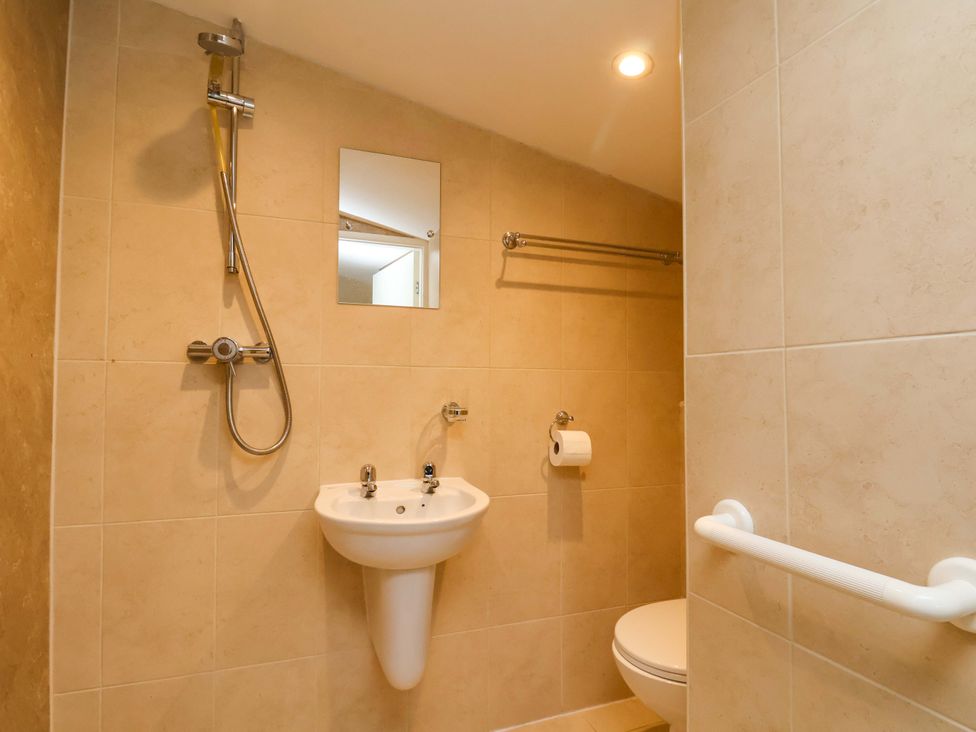 A bathroom with a shower, sink, and toilet at The Nook in Robin Hood’s Bay