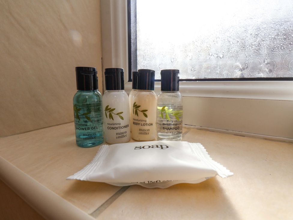 Bottles of shower gel, conditioner, body lotion, shampoo, and a soap bar at The Nook in Robin Hood’s Bay