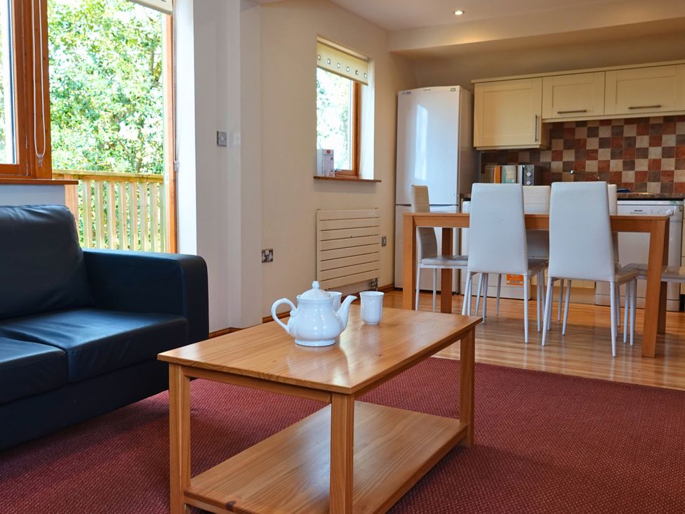 A living room with a sofa and dining area at Bracken Lodge Finlakes Holiday Park near Chudleigh