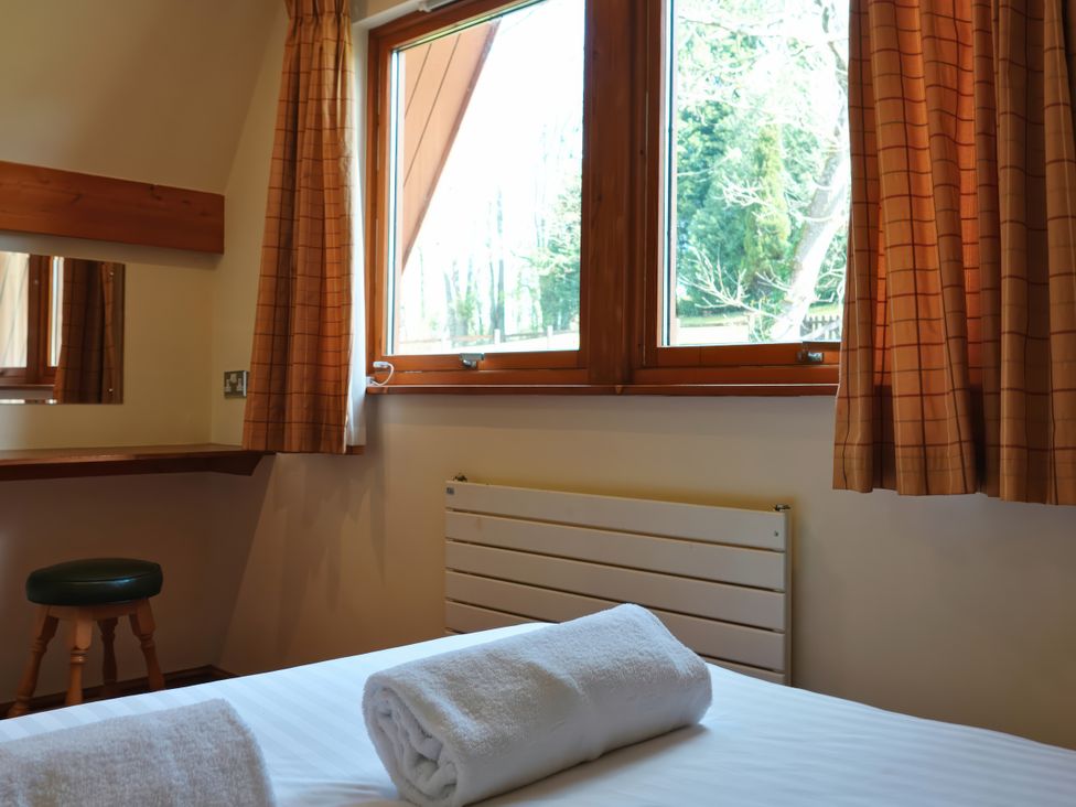 A bedroom with a window and a bed at Bracken Lodge in Finlakes Holiday Park near Chudleigh