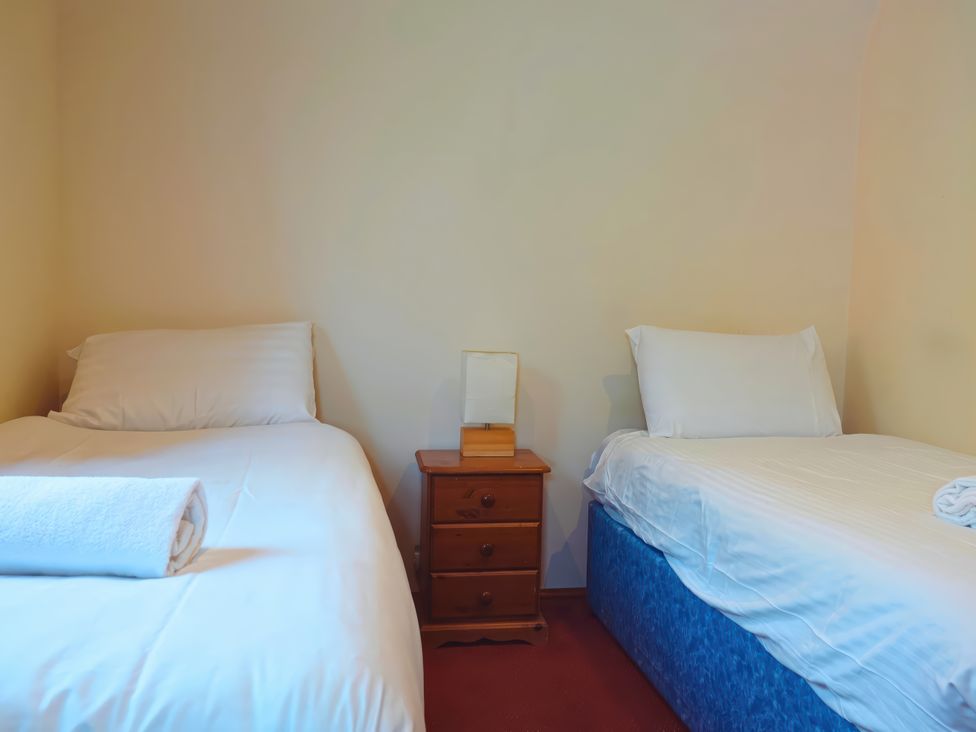 A bedroom with two beds and a table at Bracken Lodge Finlakes Holiday Park near Chudleigh