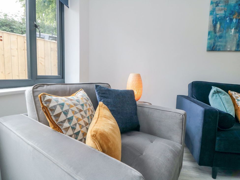 A living room with a sofa and cushions at Riverside House in Scarborough