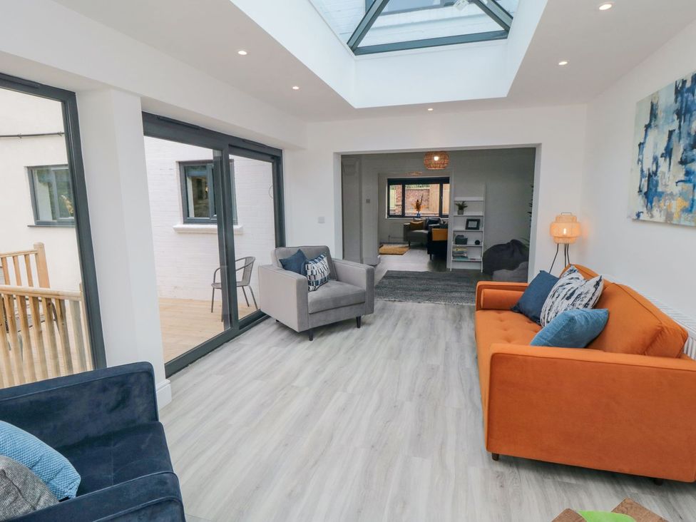A living room with sofas and windows at Riverside House in Scarborough