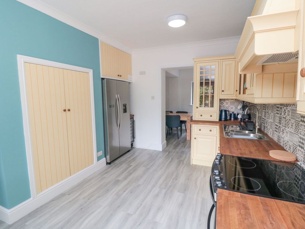 A kitchen with cabinets and a refrigerator at Riverside House in Scarborough