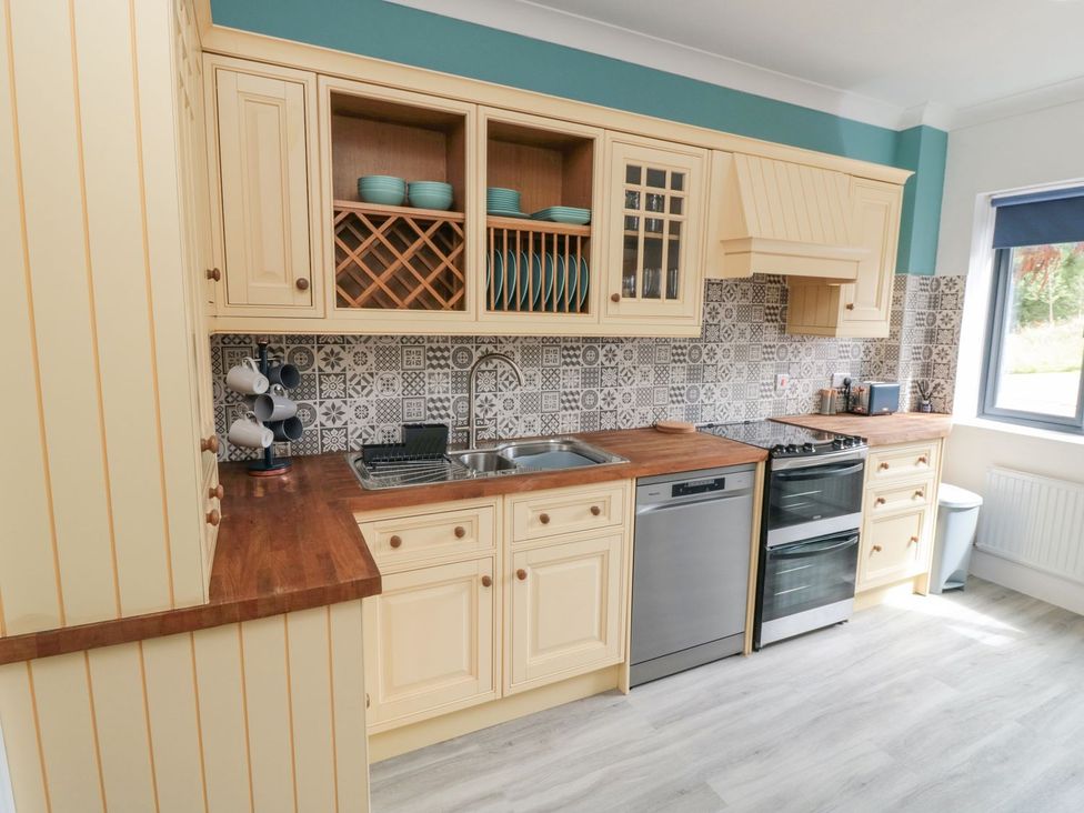 A kitchen with cabinets, countertop, sink, oven, and mugs at Riverside House in Scarborough