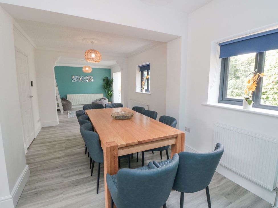 A dining room with a wooden table and chairs at Riverside House in Scarborough