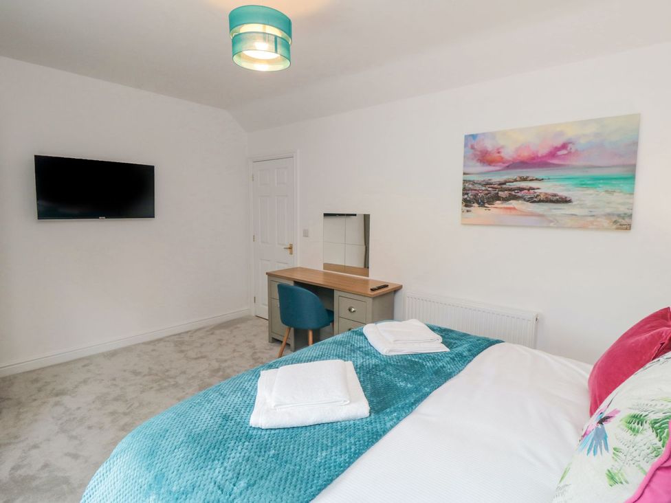 A bedroom with a bed, desk and TV at Riverside House in Scarborough