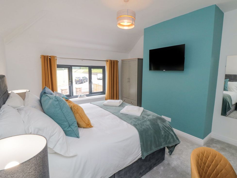 A bedroom with bed and television at Riverside House in Scarborough