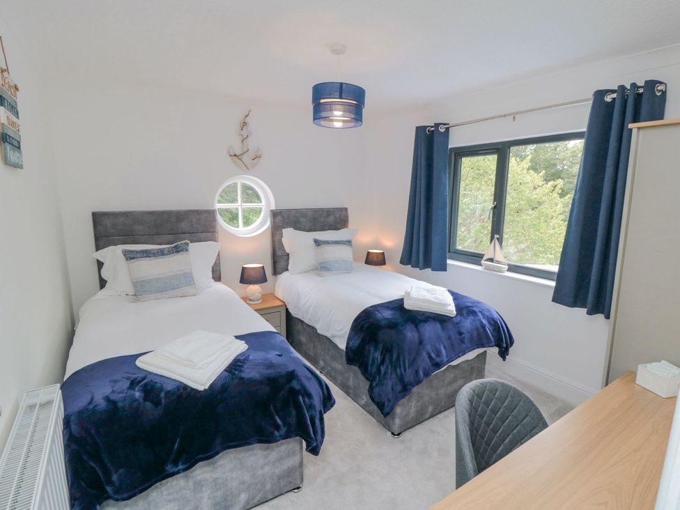 A bedroom with two beds and a desk at Riverside House in Scarborough