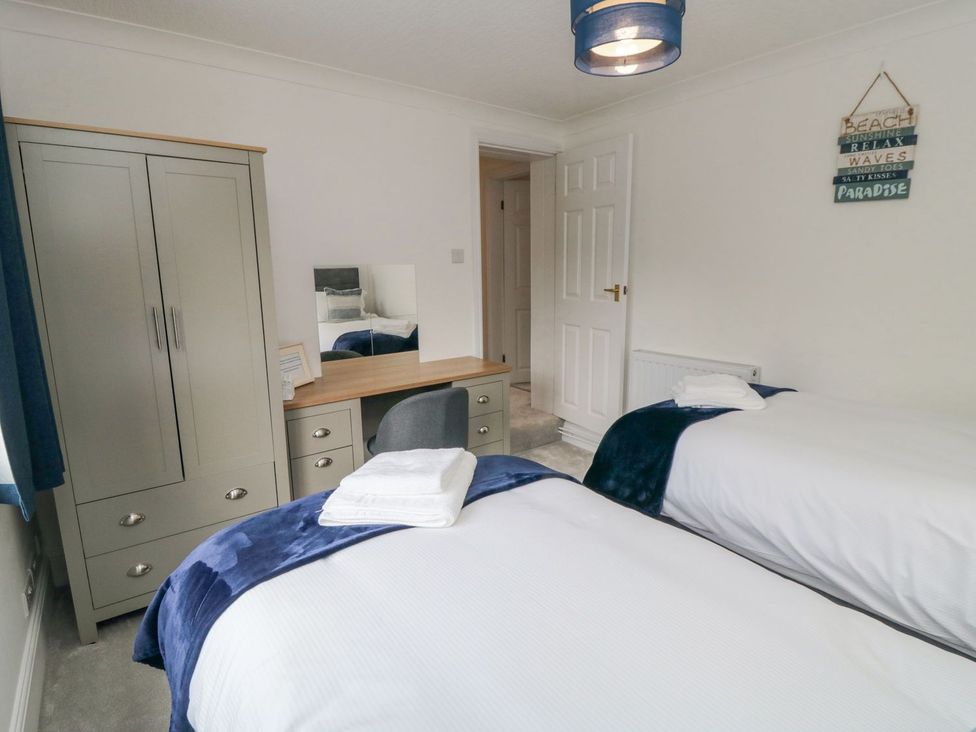 A bedroom with two beds and a desk at Riverside House in Scarborough