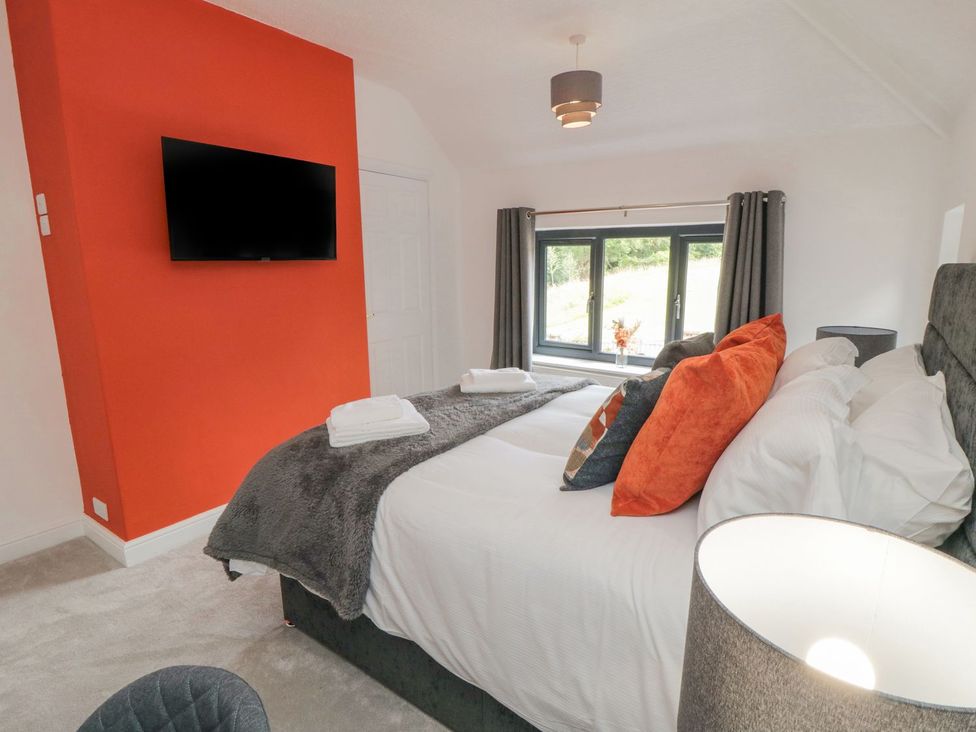 A bedroom with a bed and television at Riverside House in Scarborough