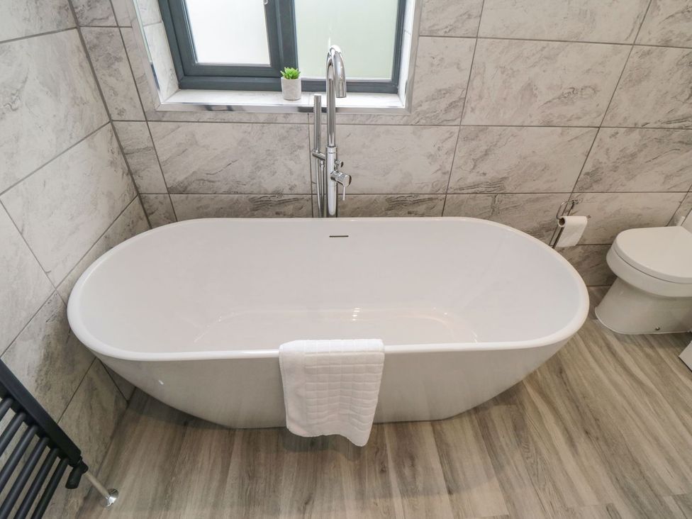 A bathroom with a bathtub and toilet at Riverside House in Scarborough