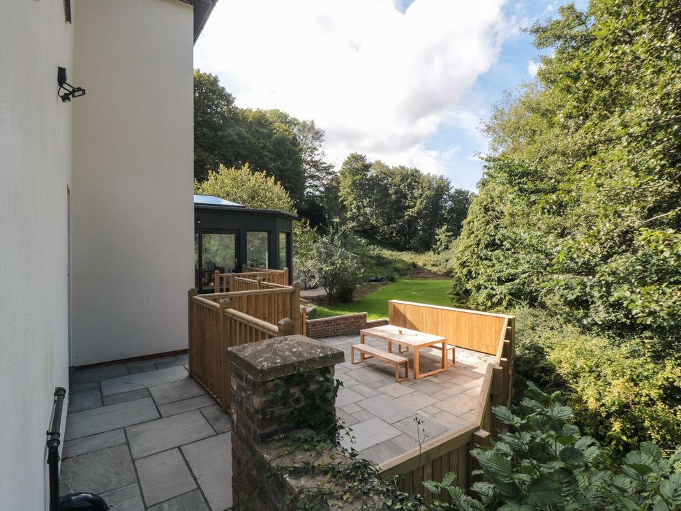 An outdoor space with a wooden deck and table at Riverside House, Scarborough