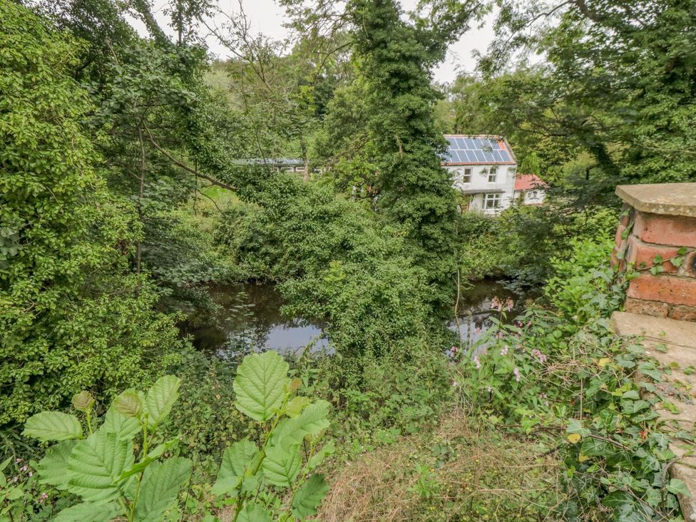 A house surrounded by trees with a river at Riverside House in Scarborough