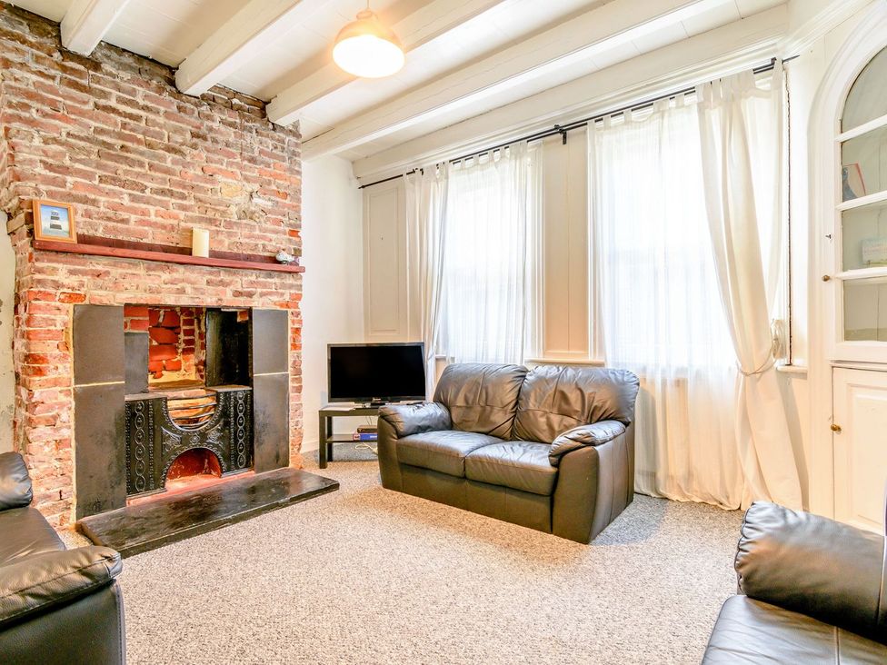 A living room with a fireplace and sofa at The Anchorage in Whitby
