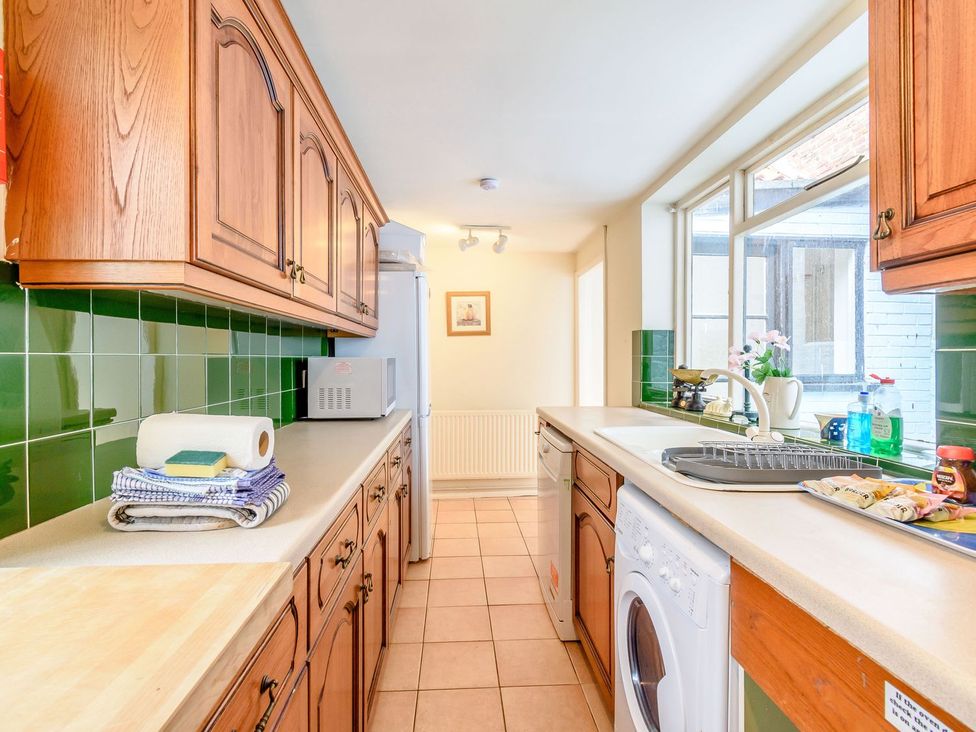 A kitchen with cabinets, refrigerator, and washing machine at The Anchorage in Whitby