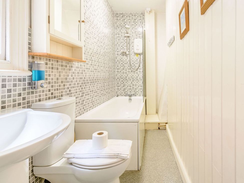 A bathroom with a bathtub, toilet, and sink at The Anchorage in Whitby