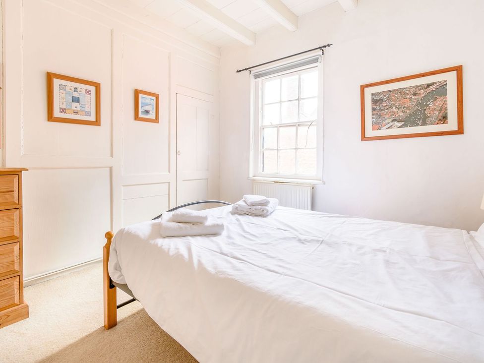 A bedroom with a bed and dresser at The Anchorage in Whitby