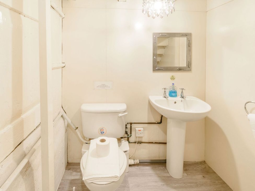 A bathroom with a toilet, sink, and mirror at The Anchorage in Whitby