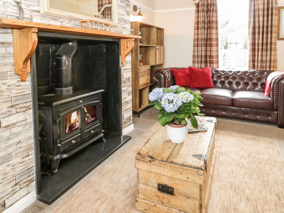 A living room with a fireplace and sofa at 2 Old Coastguard House Beaumaris