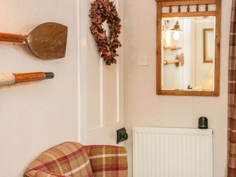 A living room with a mirror and paddle decor at 2 Old Coastguard House Beaumaris