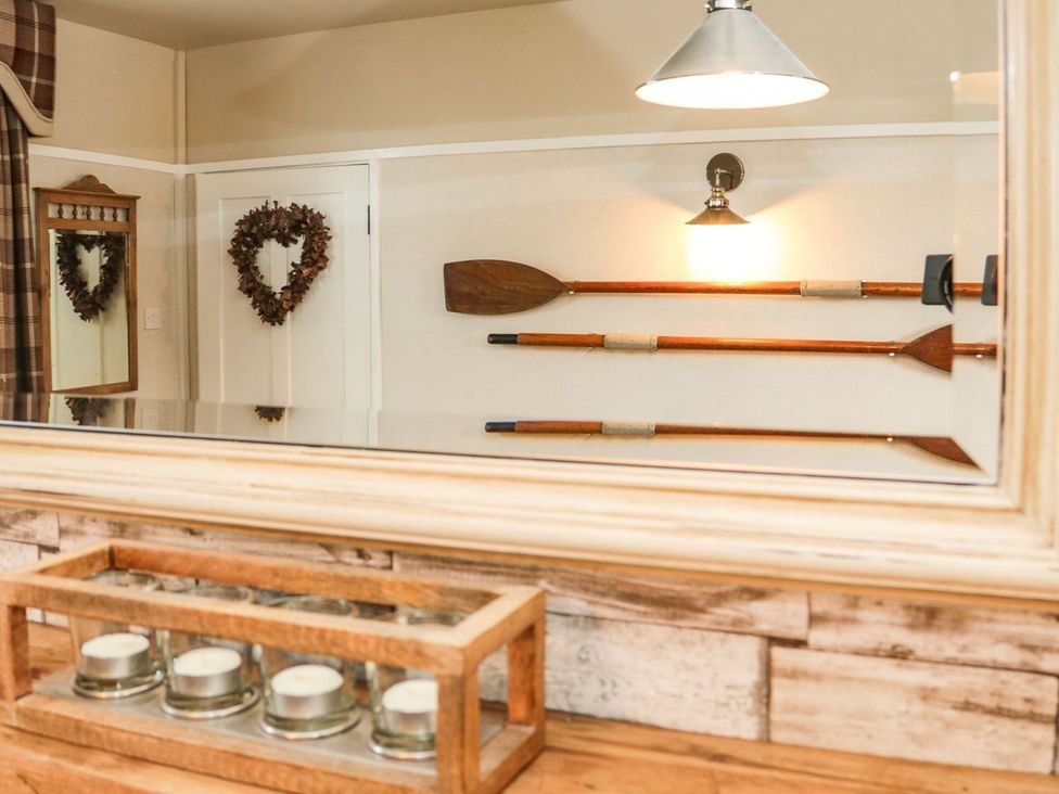 A room with wooden oars and a mirror at 2 Old Coastguard House in Beaumaris