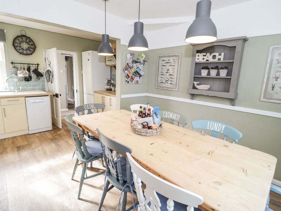 A kitchen with a dining table and chairs at 2 Old Coastguard House Beaumaris