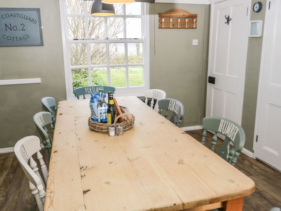 A dining room with a table and chairs at 2 Old Coastguard House in Beaumaris
