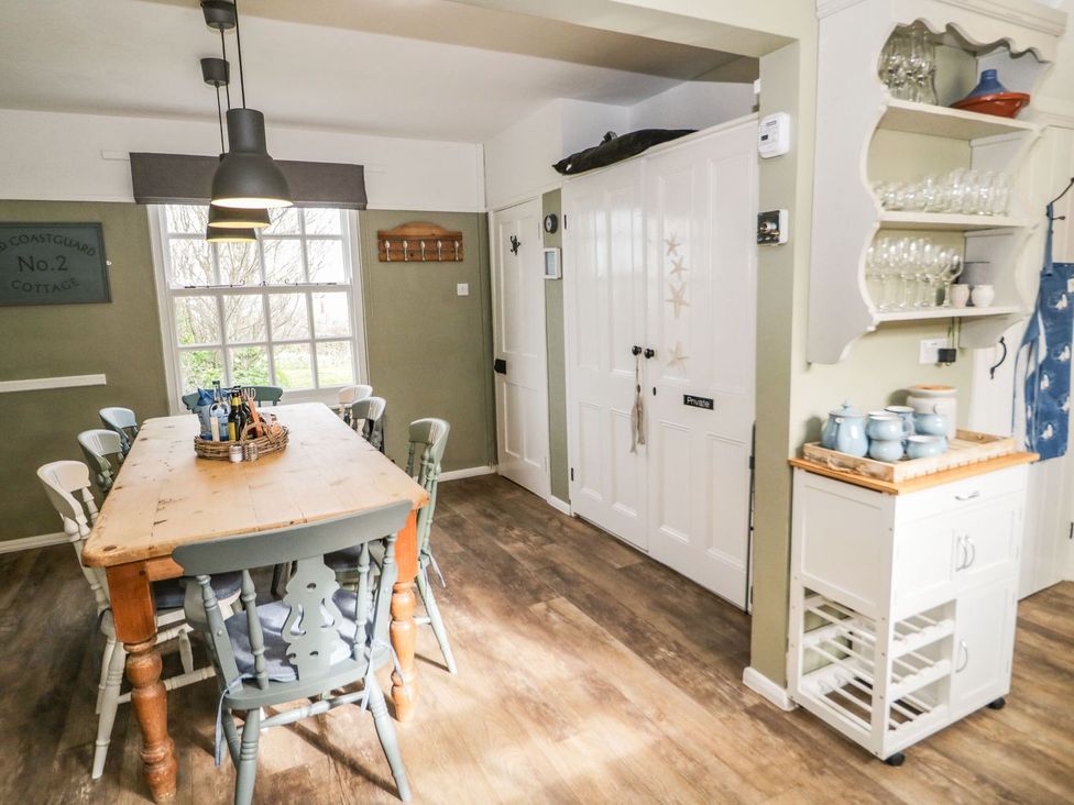 A dining room with a wooden table and chairs at 2 Old Coastguard House Beaumaris