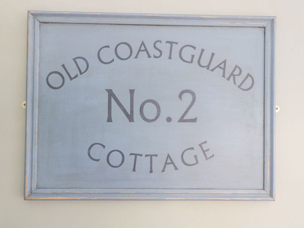 A sign reading OLD COASTGUARD No.2 COTTAGE at 2 Old Coastguard House Beaumaris