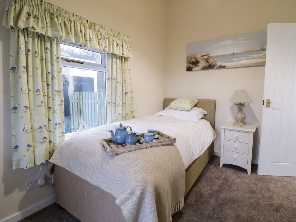 A bedroom with a bed and nightstand at 2 Old Coastguard House in Beaumaris