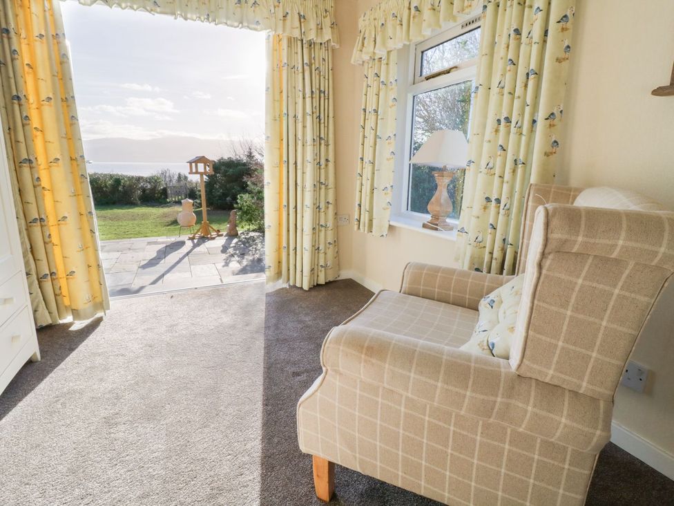 A snug with an armchair and window at 2 Old Coastguard House Beaumaris